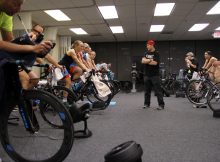 group of athletes training on stationary bicycles in a room